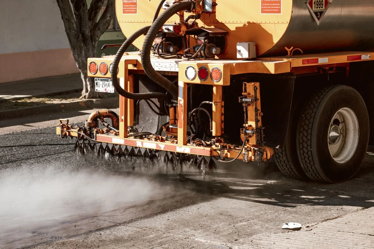 Spray bar nozzles applying a uniform tack coat across a road
