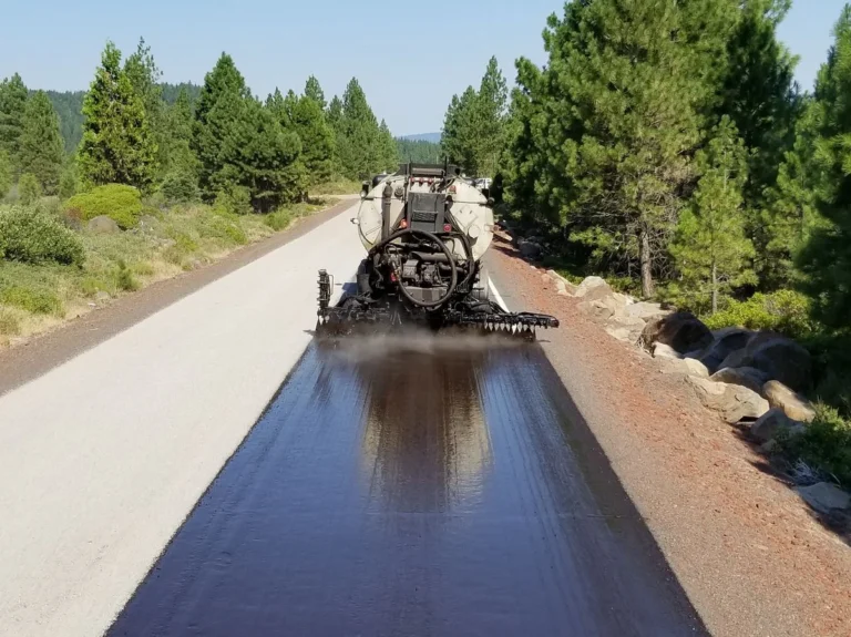 Asphalt distributor spraying tack coat emulsion onto a fresh road surface