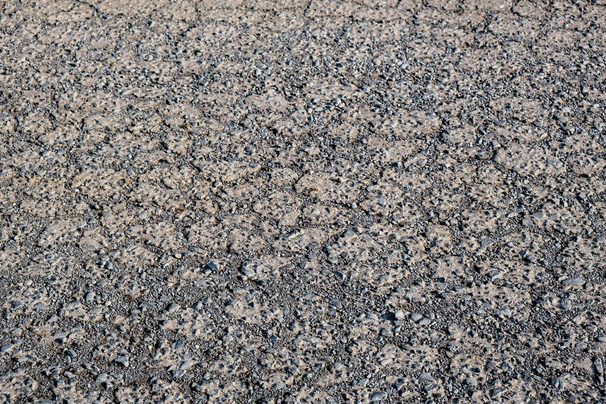 Close-up of a milled asphalt surface showing a rough, open texture
